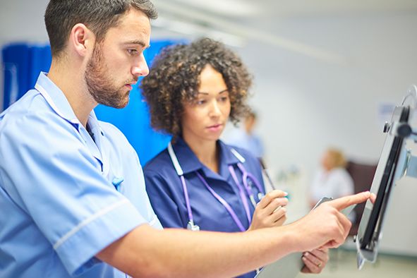 Healthcare workers at work using an ipad.