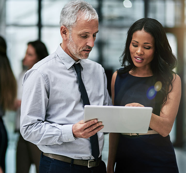 Man and woman having a discussion while looking at a tablet