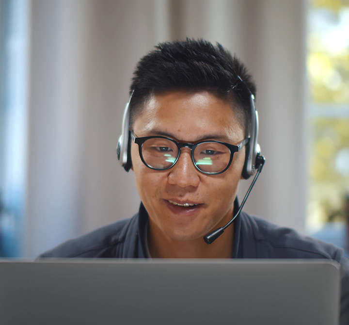 Businessman using headset on a conference call in front of a monitor