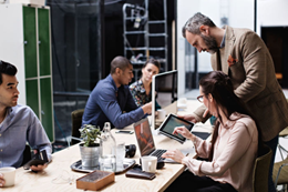 Business people happily collaborating at work with tablet in hands and wireless connectivity