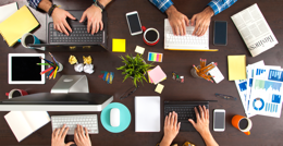 Work desk showing people hands on their laptops